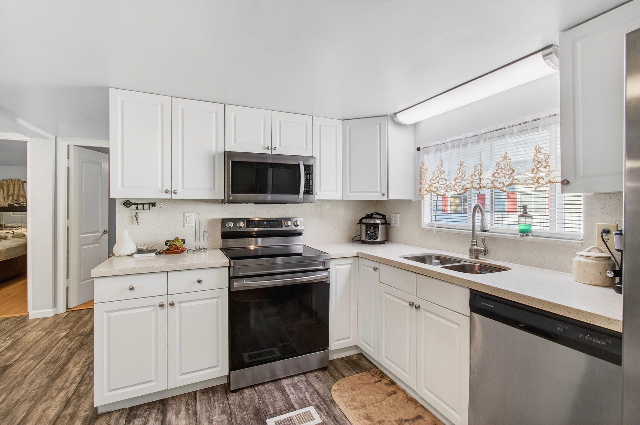 22849 Tradewind Road Boca Raton, FL 33428 - Photo 16 of 60 a kitchen with white cabinets sink and stainless steel appliances