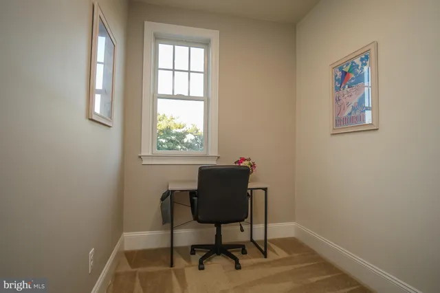 a view of a workspace room with furniture and windows