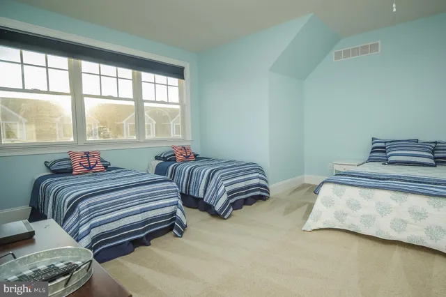 a bedroom with two beds and a large window