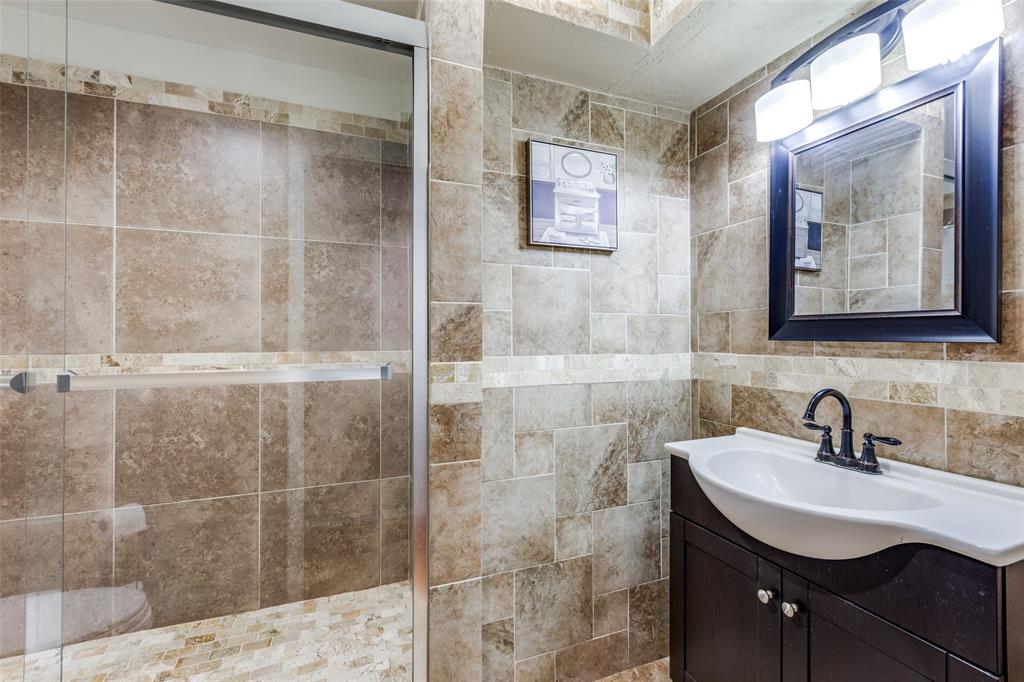 a bathroom with a sink mirror and shower