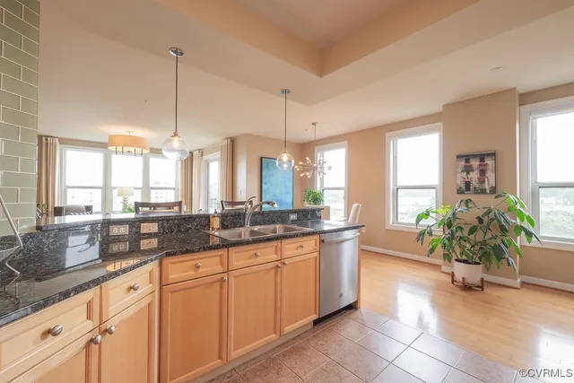 a large kitchen with granite countertop a sink and white cabinets