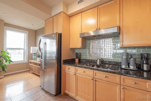 a kitchen with a refrigerator a sink and cabinets