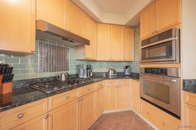 a kitchen with stainless steel appliances granite countertop a sink stove and microwave