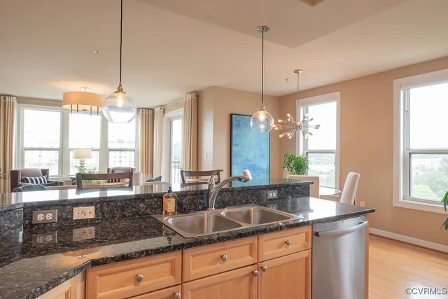 a kitchen with granite countertop a sink and white cabinets