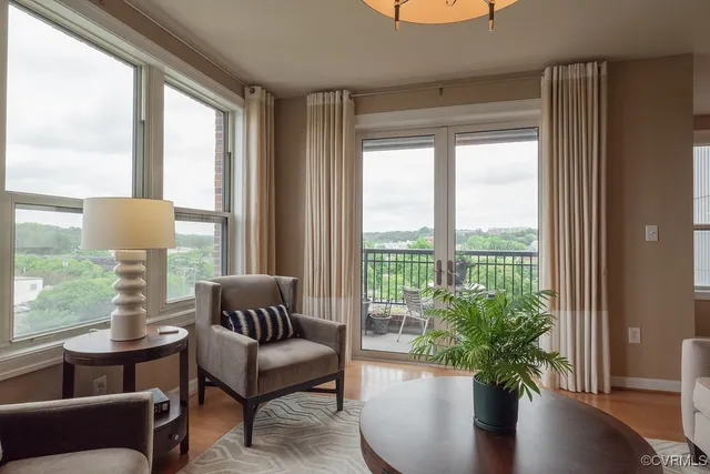 a living room with furniture potted plant and a large window