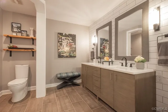 a bathroom with a toilet sink and mirror