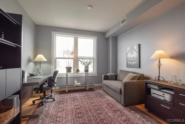 a living room with furniture a flat screen tv and a large window