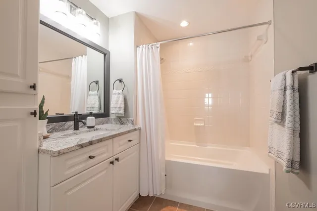 a bathroom with a granite countertop sink a mirror a shower and a bathtub