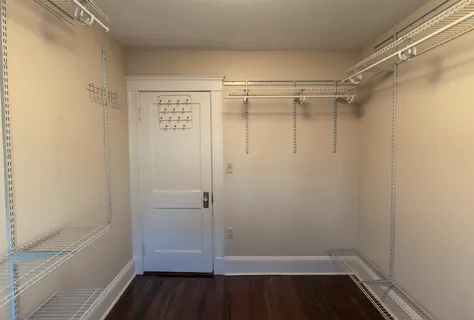 a view of walk in closet with wooden floor