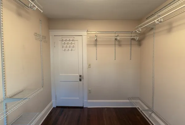 a view of walk in closet with wooden floor