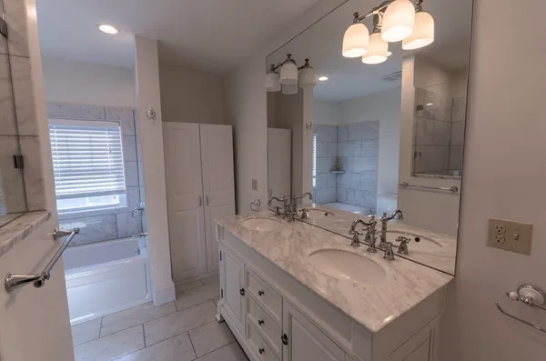 a bathroom with a sink double vanity granite and a mirror