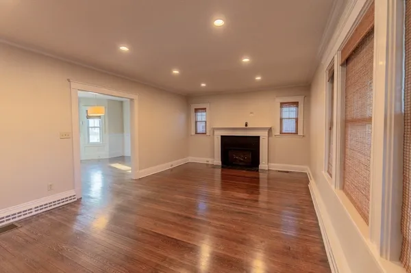 an empty room with wooden floor and fireplace