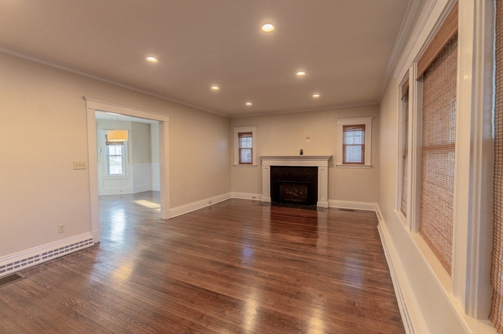 1000 South Street Boston, MA 02131 - Photo 5 of 22 an empty room with wooden floor and fireplace