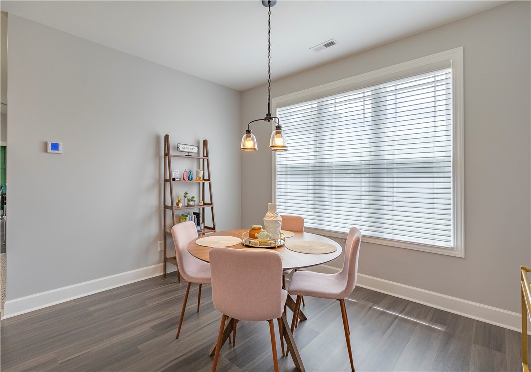 3080 McGee Road Iva, SC 29655 - Photo 6 of 49 Natural light streams into this intimate dining space, featuring durable wood flooring and a modern pendant light.