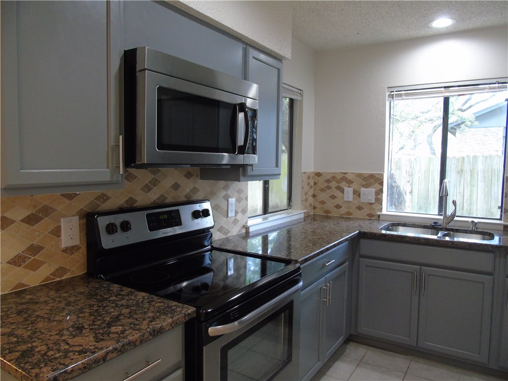 a kitchen with a sink stove and microwave