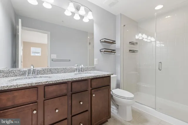 a bathroom with a granite countertop sink a toilet and a mirror