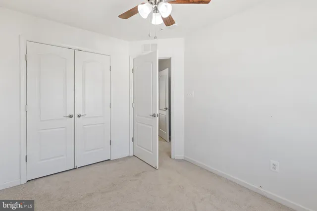 an empty room with a chandelier fan