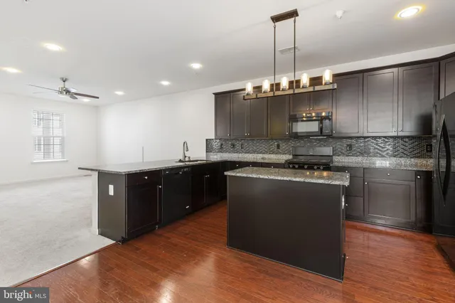 a kitchen with stainless steel appliances granite countertop a sink a stove and a refrigerator