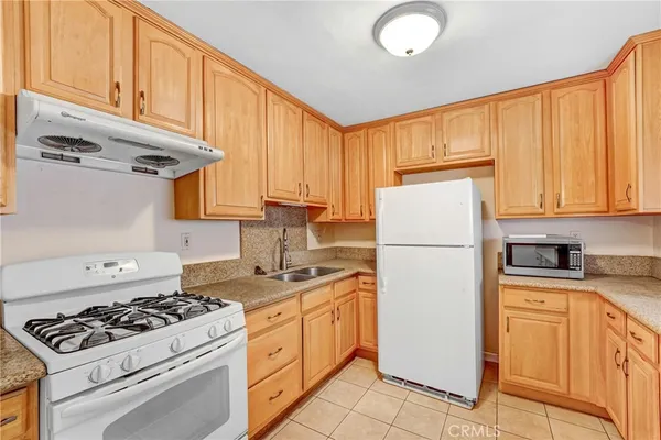 a kitchen with a appliances a sink cabinets and a window