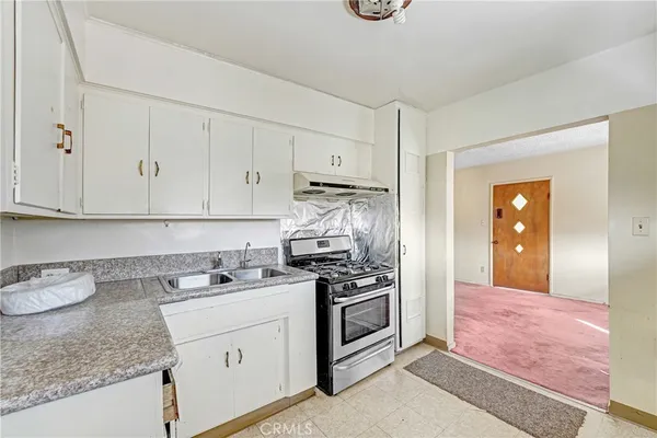 a kitchen with granite countertop cabinets stainless steel appliances and a counter space
