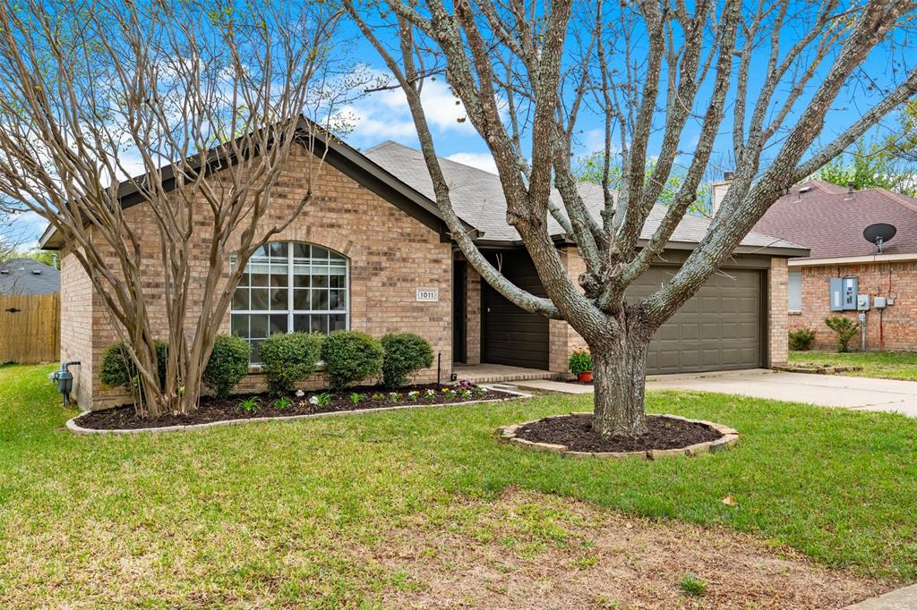 1011 Ridgecrest Drive McKinney, TX 75069 - Photo 3 of 31 Brick exterior featuring an arched window, a two-car garage, and a mature tree in the front yard