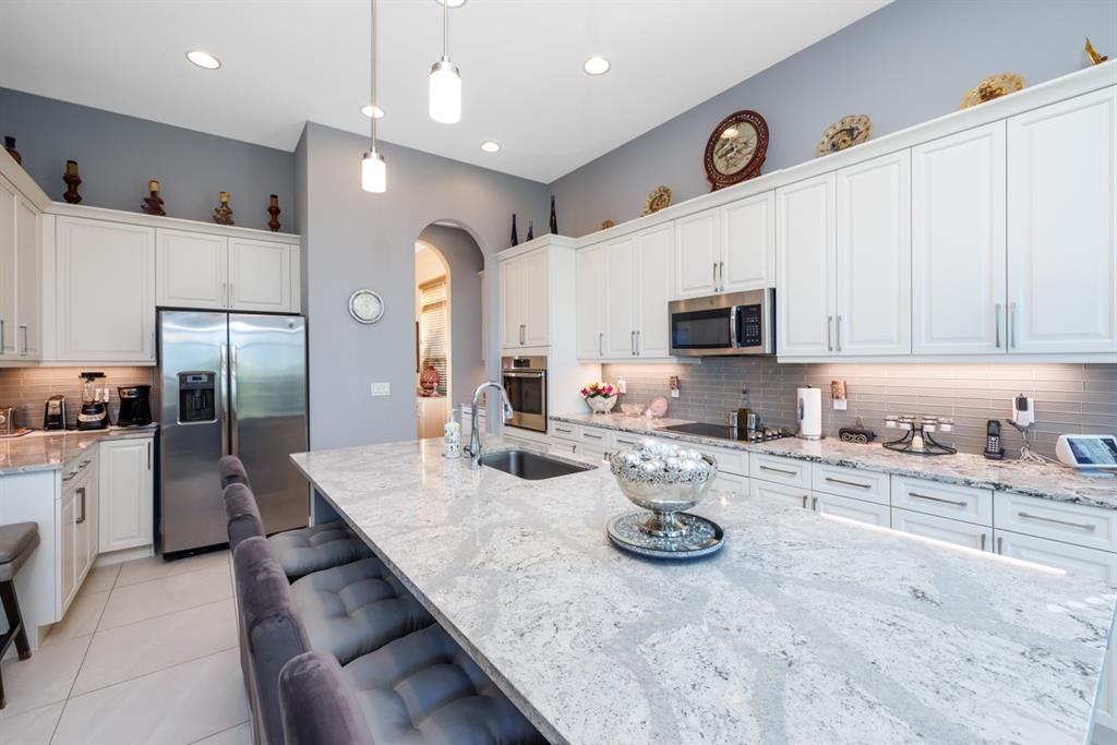 21864 Southwest Tivolo Way Port St. Lucie, FL 34986 - Photo 16 of 40 a kitchen with granite countertop stainless steel appliances stove microwave and cabinets