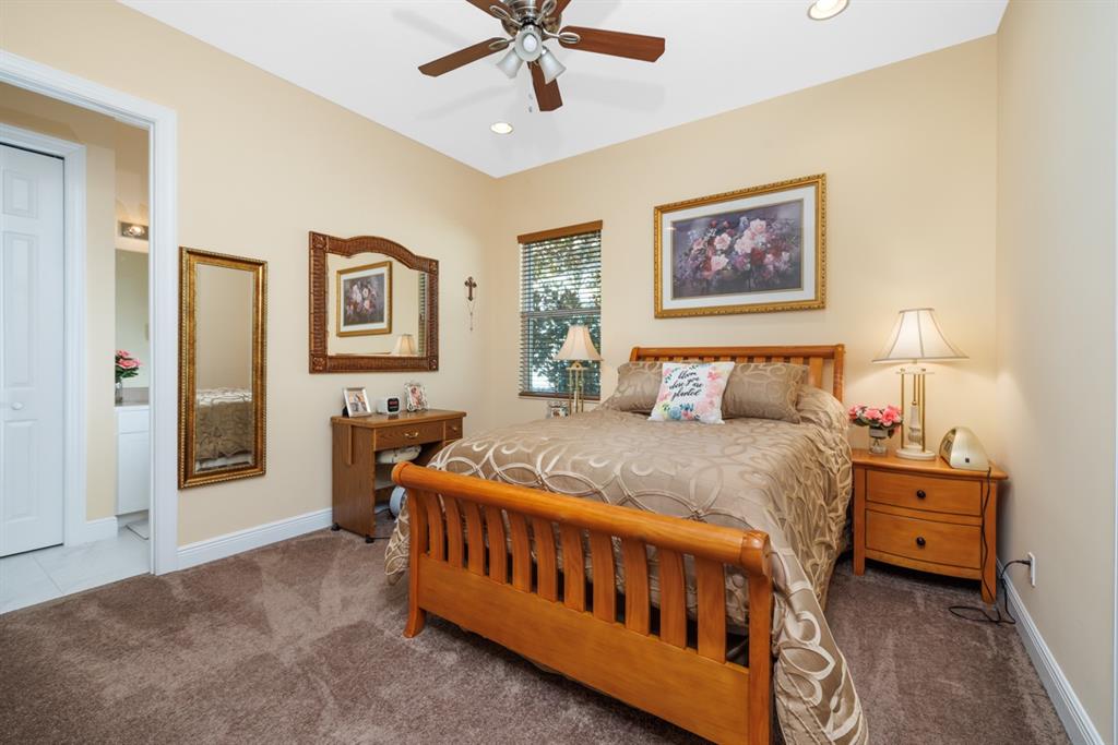 21864 Southwest Tivolo Way Port St. Lucie, FL 34986 - Photo 25 of 40 a bedroom with a bed and a chandelier
