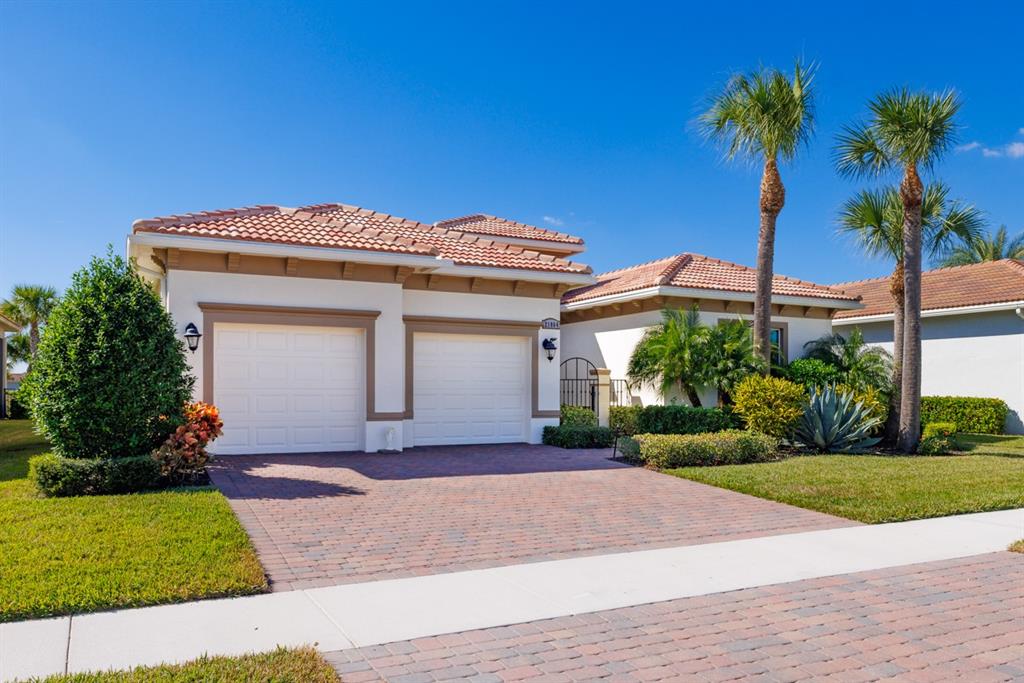 21864 Southwest Tivolo Way Port St. Lucie, FL 34986 - Photo 5 of 40 a front view of a house with a yard and garage