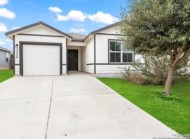 a front view of a house with a garden and yard