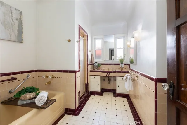 a kitchen with stainless steel appliances a refrigerator a sink and white cabinets