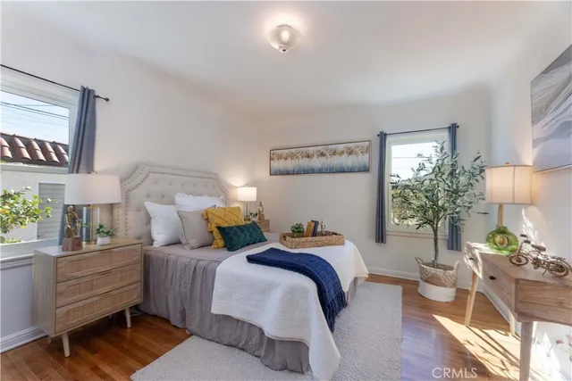 a bedroom with two beds and potted plant with chair