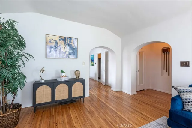 a view of a workspace room with wooden floor and furniture