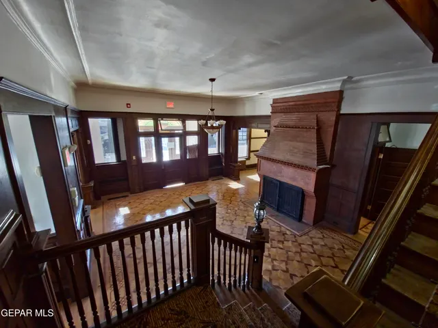 a view of a hallway with wooden floor and a chandelier