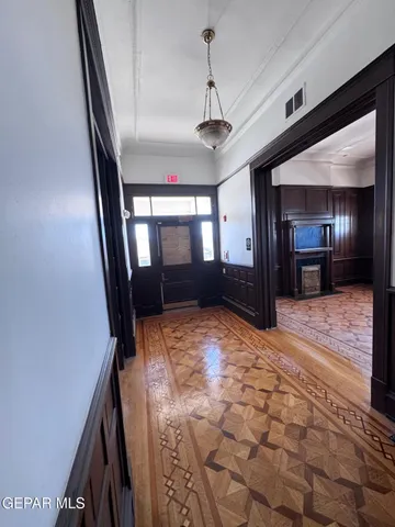 a view of a hallway with wooden floor and a chandelier