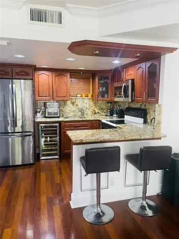 a kitchen with stainless steel appliances granite countertop a sink and a refrigerator