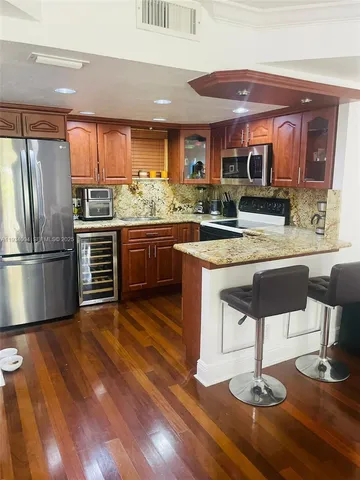 a kitchen with stainless steel appliances granite countertop a stove refrigerator and cabinets