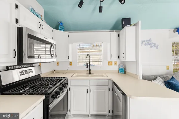 a kitchen with stainless steel appliances a stove refrigerator sink and microwave