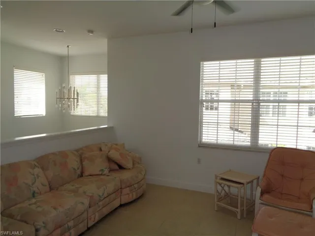 a living room with furniture a rug and a window