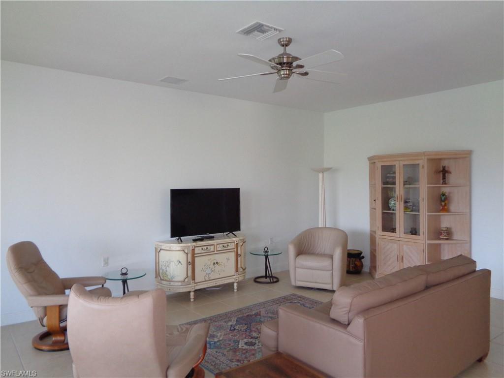 709 Regency Reserve Circle, Unit 6003 Naples, FL 34119 - Photo 18 of 44 a living room with furniture and a flat screen tv