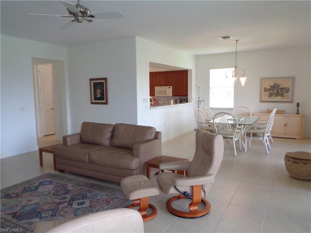 709 Regency Reserve Circle, Unit 6003 Naples, FL 34119 - Photo 22 of 44 a living room with furniture a rug and a window