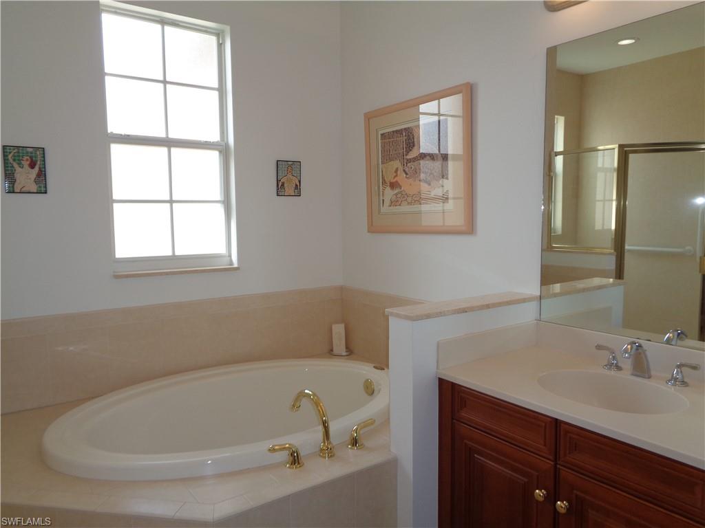 709 Regency Reserve Circle, Unit 6003 Naples, FL 34119 - Photo 27 of 44 a white bath tub sitting next to a white sink