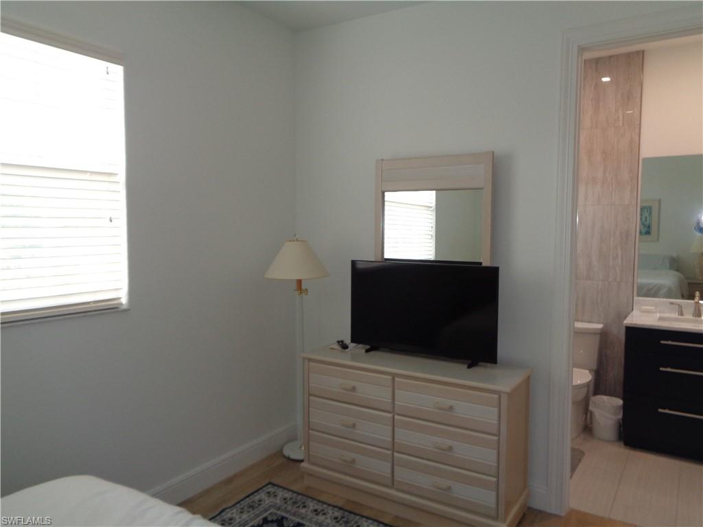 709 Regency Reserve Circle, Unit 6003 Naples, FL 34119 - Photo 29 of 44 a room with a flat screen tv and a window