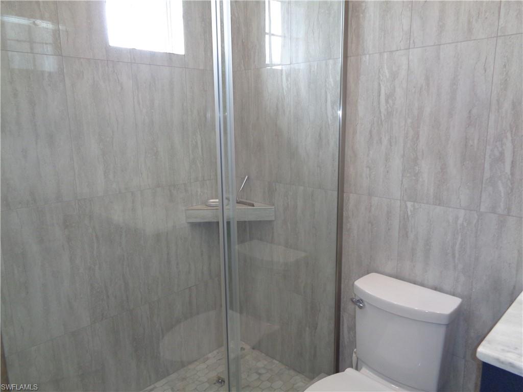 709 Regency Reserve Circle, Unit 6003 Naples, FL 34119 - Photo 30 of 44 a bathroom with a shower and a toilet