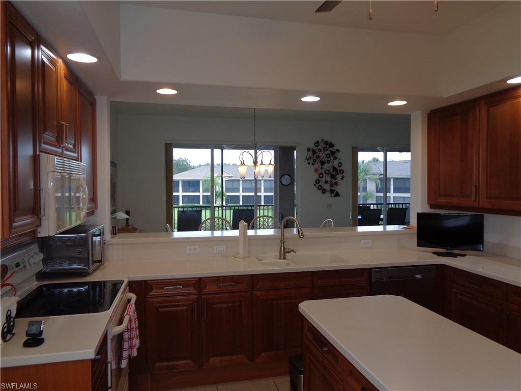 709 Regency Reserve Circle, Unit 6003 Naples, FL 34119 - Photo 9 of 44 Kitchen featuring black appliances, a chandelier, recessed lighting, ceiling fan, and a peninsula