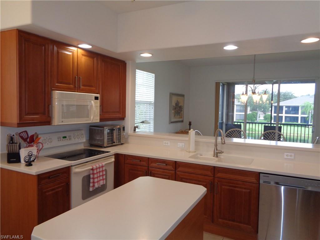 709 Regency Reserve Circle, Unit 6003 Naples, FL 34119 - Photo 10 of 44 a kitchen with stainless steel appliances granite countertop a sink stove and cabinets