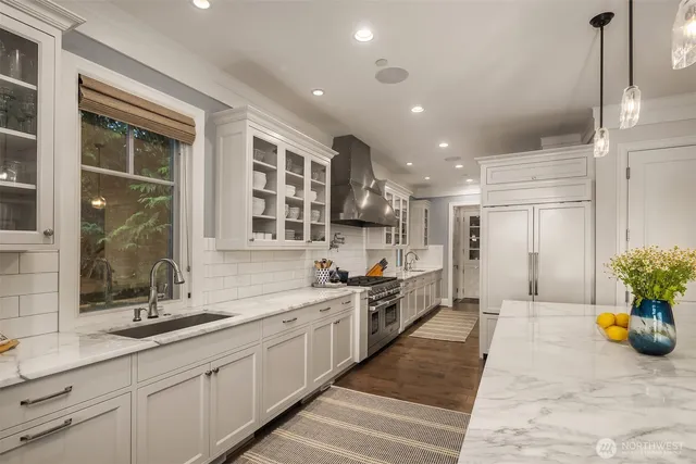 a large kitchen with stainless steel appliances kitchen island granite countertop a sink and cabinets