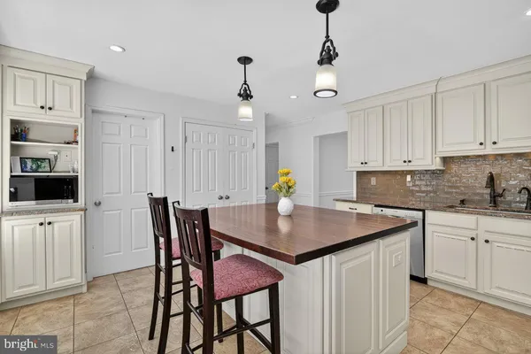 a kitchen with a table chairs and white cabinets