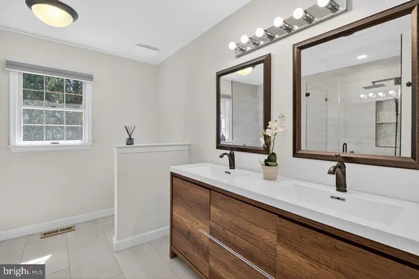 a bathroom with a double vanity sink and a mirror