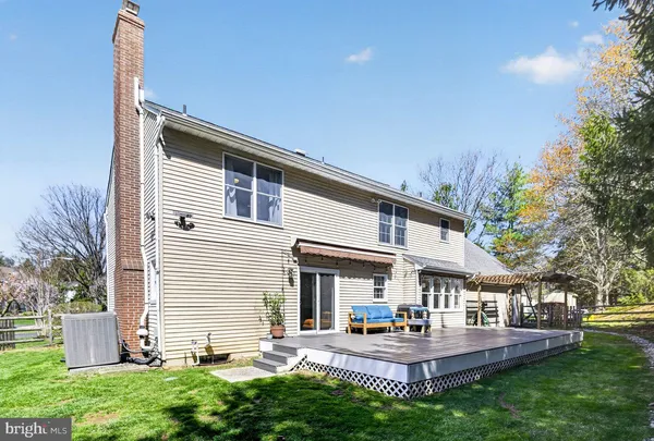 a view of an house with backyard outdoor seating and trees