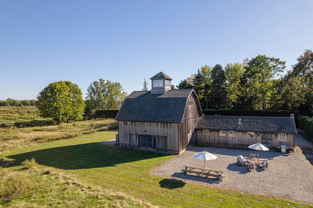 View of barn featuring a lawn